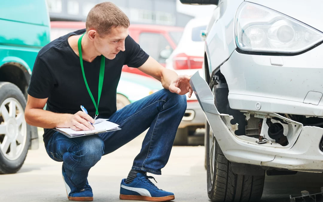 Insurance agent evaluating a damaged car.